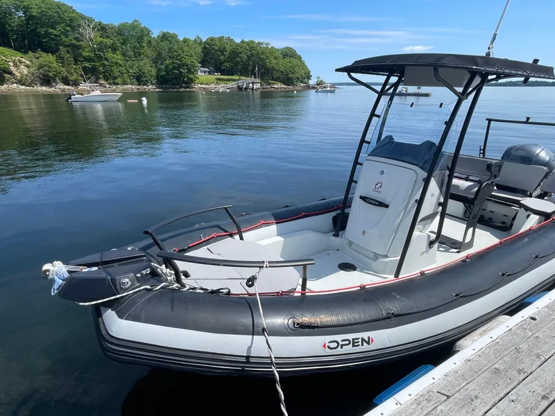 Slide: The Image of 2022 Zodiac Open 7 boat docked on calm water with scenic background. - 3