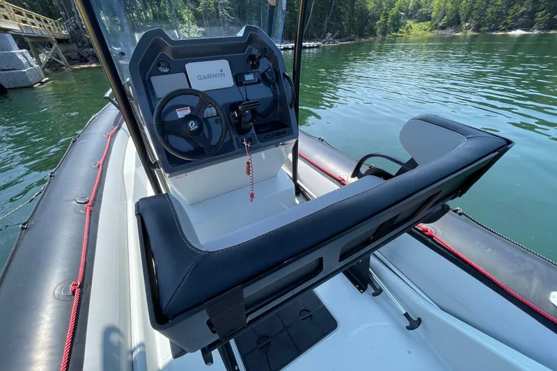 Slide: The Image of 2022 Zodiac Open 7 boat cockpit with Garmin navigation, docked on a serene lake. - 30