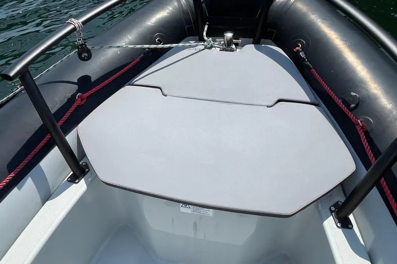 Slide: The Image of 2022 Zodiac Open 7 boat deck with seating and safety railings on water. - 34