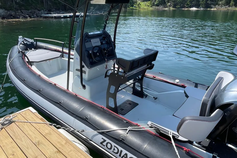 Slide: The Image of 2022 Zodiac Open 7 boat docked on calm water, featuring sleek design and modern controls. - 4