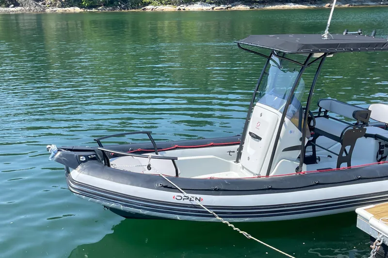 Slide: The Image of 2022 Zodiac Open 7 boat docked on calm water, featuring sleek design and modern features. - 8