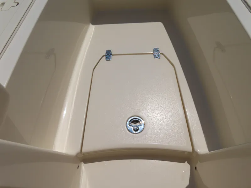 Slide: The Image of 2022 Scout 255 Dorado boat storage compartment with latch, beige interior. - 16