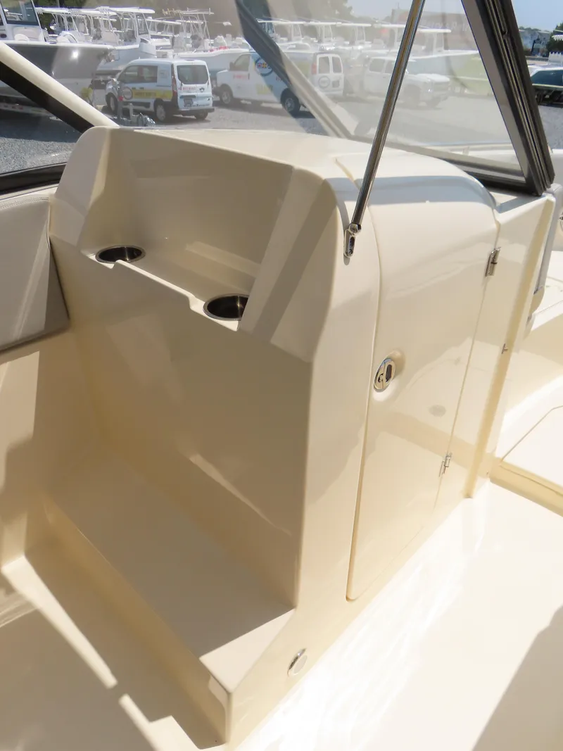 Slide: The Image of 2022 Scout 255 Dorado boat interior with cup holders and storage compartment. - 24