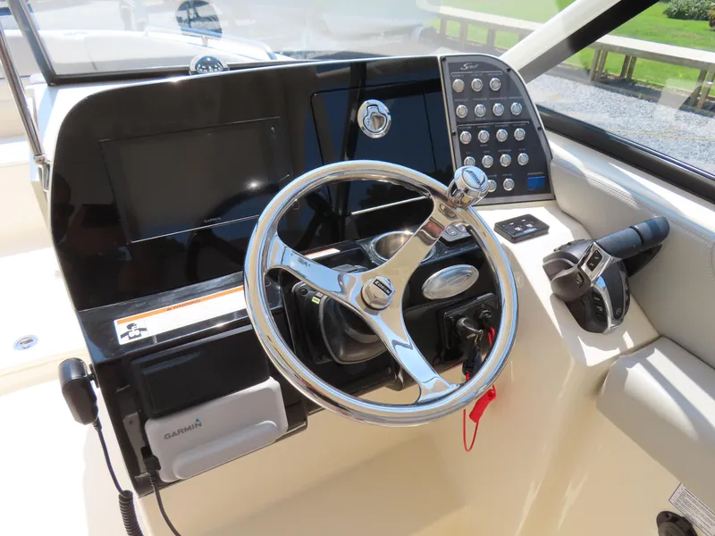 Slide: The Image of 2022 Scout 255 Dorado boat dashboard with steering wheel and control panel. - 27
