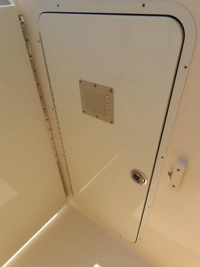 Slide: The Image of 2022 Scout 255 Dorado boat compartment door with latch and ventilation panel. - 33