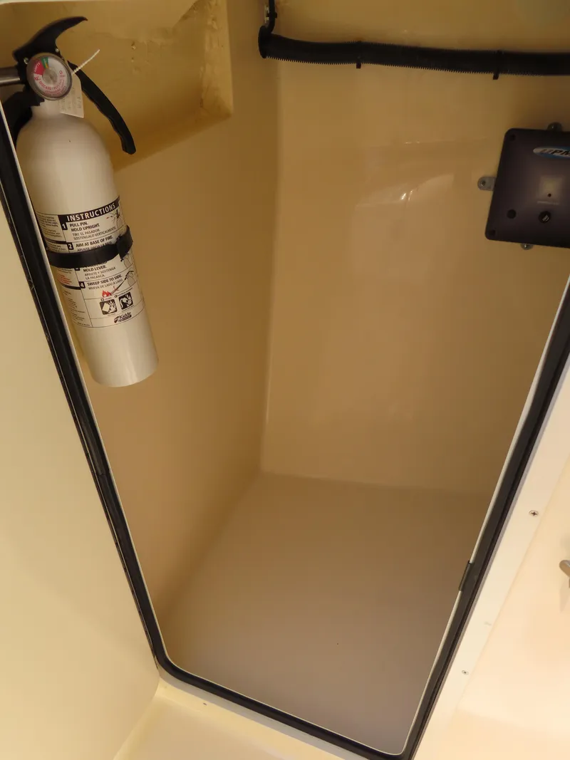 Slide: The Image of 2022 Scout 255 Dorado storage compartment with fire extinguisher. - 34