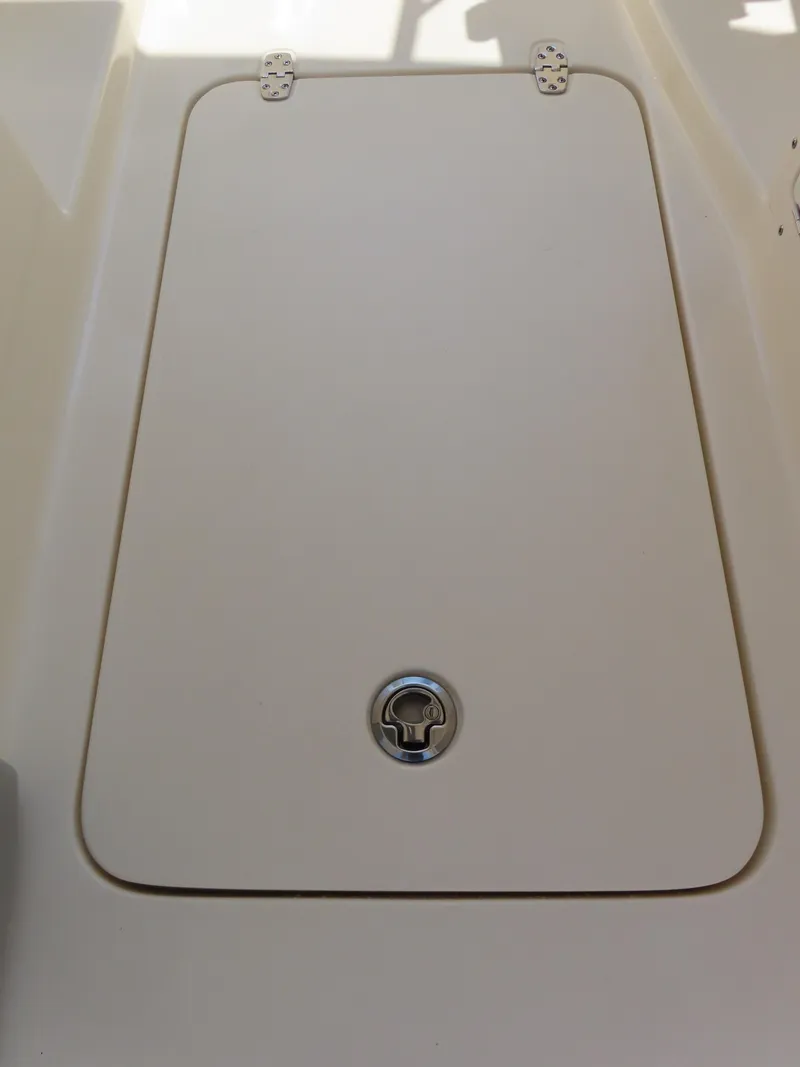 Slide: The Image of 2022 Scout 255 Dorado boat hatch with metal latch, beige surface. - 35