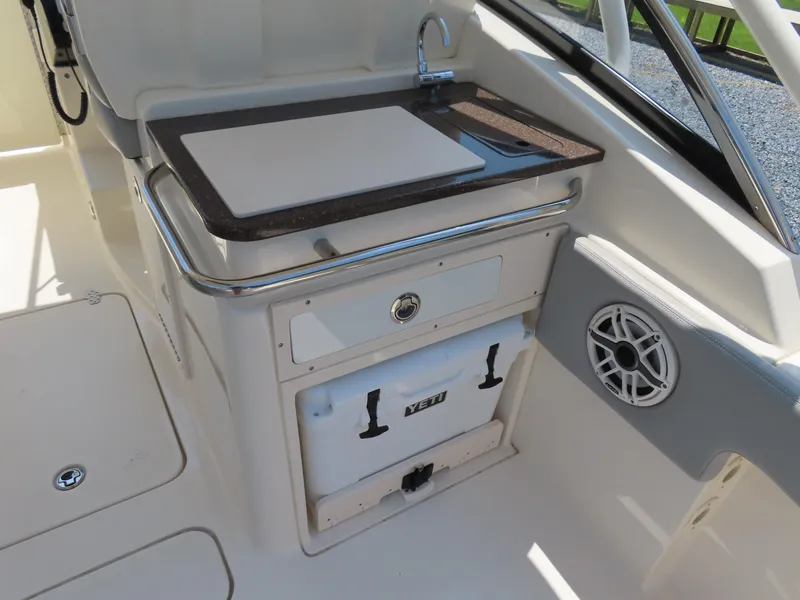 Slide: The Image of 2022 Scout 255 Dorado boat interior with sink, cutting board, and Yeti cooler. - 37