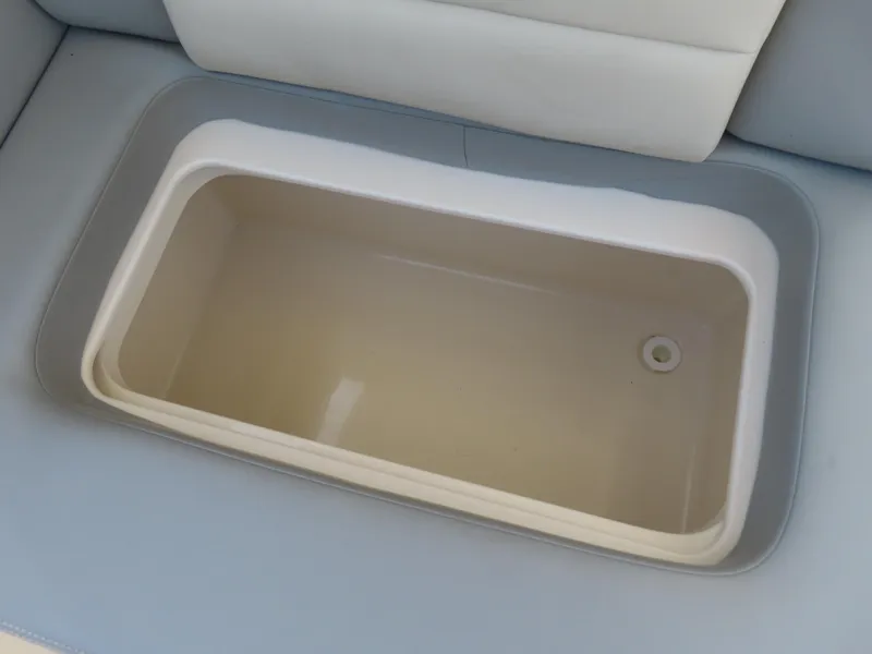 Slide: The Image of 2022 Scout 255 Dorado boat storage compartment, beige interior, white and gray seating. - 40