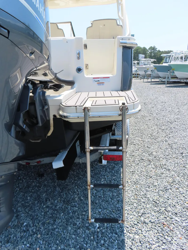 Slide: The Image of 2022 Scout 255 Dorado boat with swim platform and ladder on gravel surface. - 6