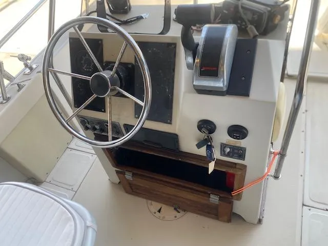 Slide: The Image of 1989 Boston Whaler 20 Outrage anchor storage compartment with open hatch and coiled rope. - 15