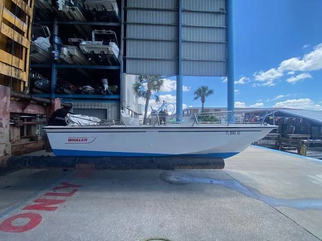 Slide: The Image of 1989 Boston Whaler 20 Outrage boat interior with two white seats and canopy. - 17