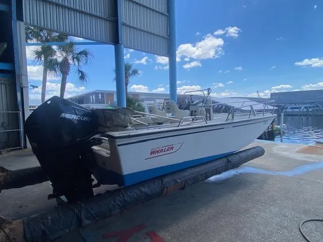 Slide: The Image of 1989 Boston Whaler 20 Outrage boat stored in a marina with blue skies. - 18