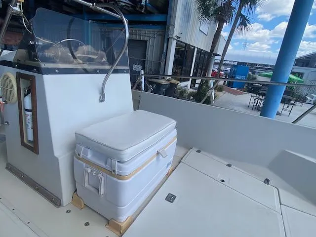 Slide: The Image of 1989 Boston Whaler 20 Outrage boat interior with seating and console, dockside view. - 20