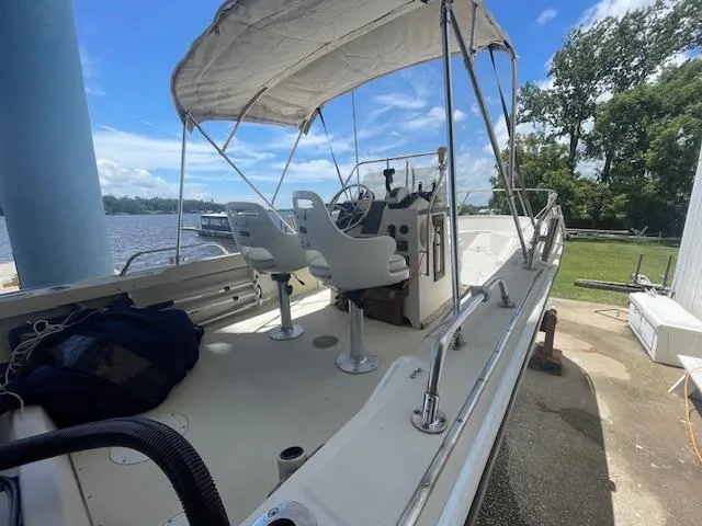 Slide: The Image of 1989 Boston Whaler 21 Outrage with Mercury outboard motor, docked near a waterfront. - 3