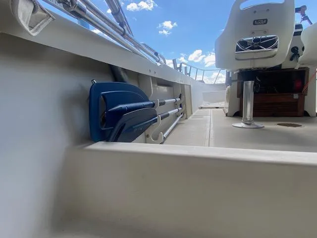 Slide: The Image of 1989 Boston Whaler 20 Outrage interior with seating and storage, under a clear blue sky. - 33