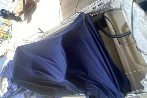 Slide: The Image of 1989 Boston Whaler 20 Outrage boat with blue cover, docked at marina. - 37