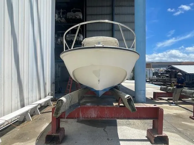 Slide: The Image of 1989 Boston Whaler 21 Outrage boat in dry dock, under a metal shelter. - 4