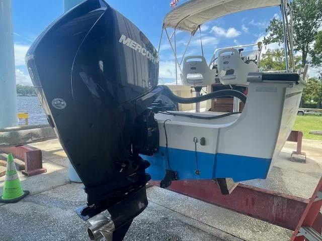 Slide: The Image of 1989 Boston Whaler 21 Outrage boat on a lift in a marina setting. - 6