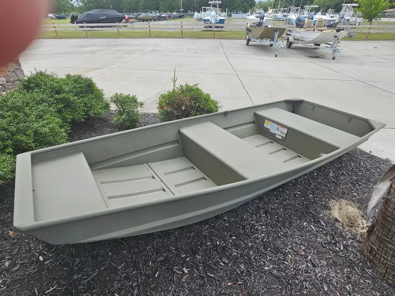 Slide: The Image of 2026 Tracker Grizzly 1236 Jon boat displayed outdoors on a dealership lot. - 3