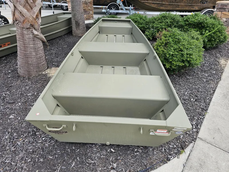 Slide: The Image of 2026 Tracker Grizzly 1236 Jon boat displayed outdoors near greenery. - 5