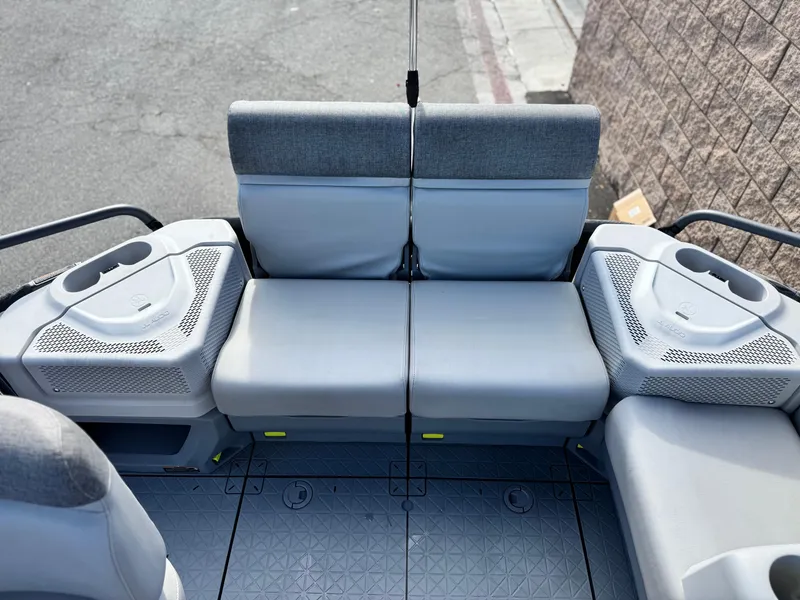 Slide: The Image of 2023 Sea-Doo Switch Sport 18 interior seating with gray upholstery and cup holders. - 18