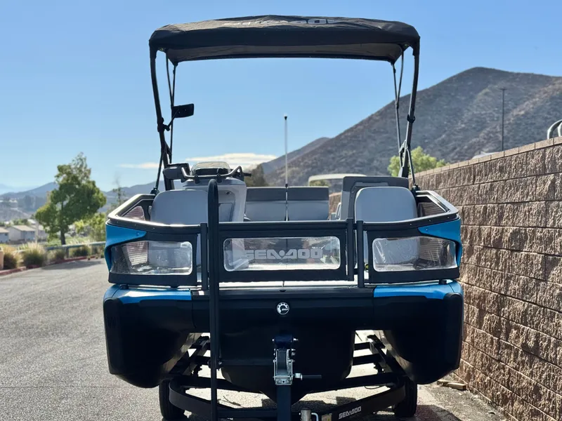 Slide: The Image of 2023 Sea-Doo Switch Sport 18 parked on a sunny day with mountain backdrop. - 2