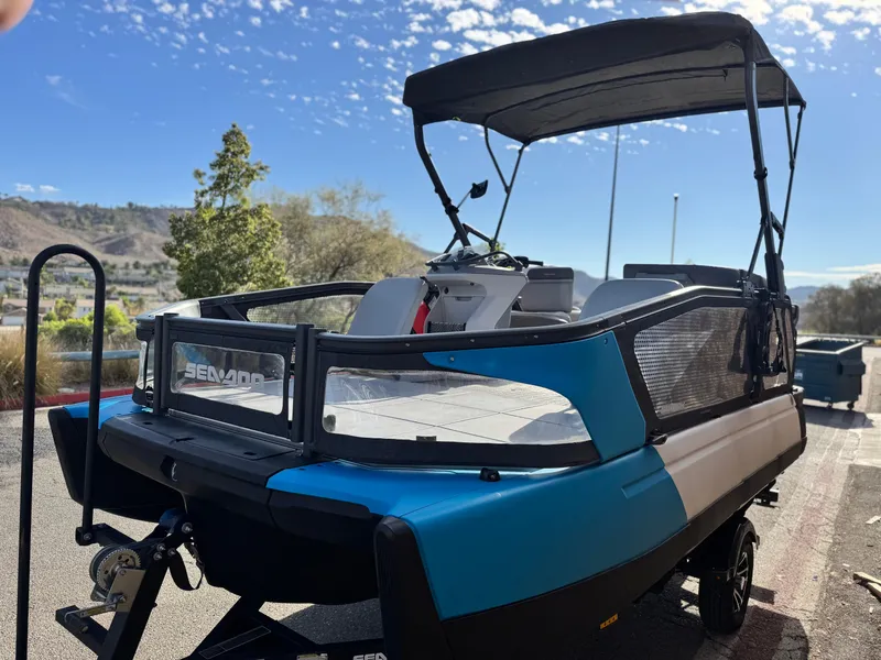 Slide: The Image of 2023 Sea-Doo Switch Sport 18 boat with canopy, parked outdoors under a clear sky. - 4