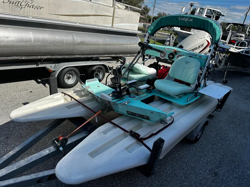 Slide: The Image of 2020 CraigCat CATCHIT catamaran on trailer, featuring teal seats and canopy. - 1