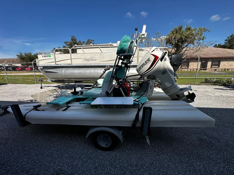 Slide: The Image of 2020 CraigCat CATCHIT boat on trailer with Evinrude motor, parked outdoors. - 2