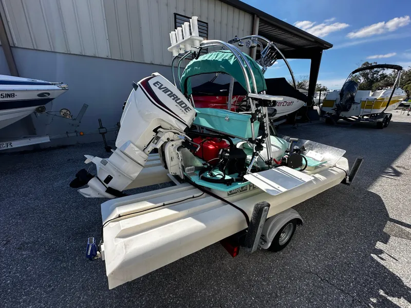 Slide: The Image of 2020 CraigCat CATCHIT boat with Evinrude motor on a trailer, parked outdoors. - 4