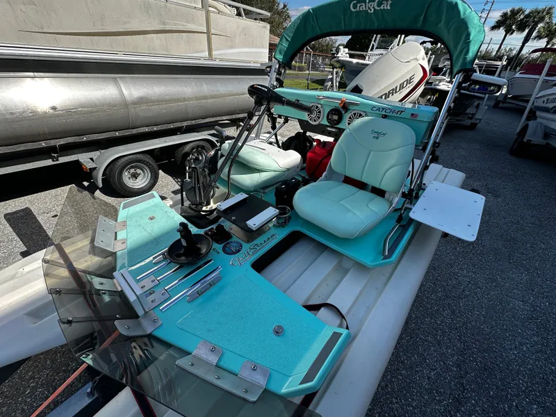 Slide: The Image of 2020 CraigCat CATCHIT boat with teal seating and controls, parked on a trailer. - 7