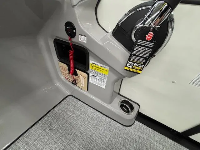 Slide: The Image of Control panel of 2025 Harris Sunliner 230 boat with safety instructions and cup holder. - 13