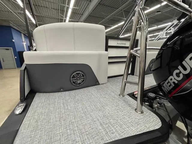 Slide: The Image of 2025 Harris Sunliner 230 boat interior with speaker, ladder, and Mercury engine. - 4