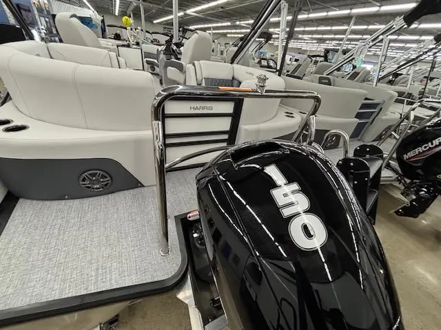 Slide: The Image of 2025 Harris Sunliner 230 pontoon boat with 150 horsepower engine in showroom. - 5