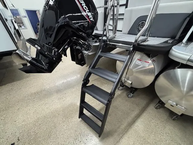 Slide: The Image of 2025 Harris Sunliner 230 boat with Mercury engine and boarding ladder in showroom. - 6