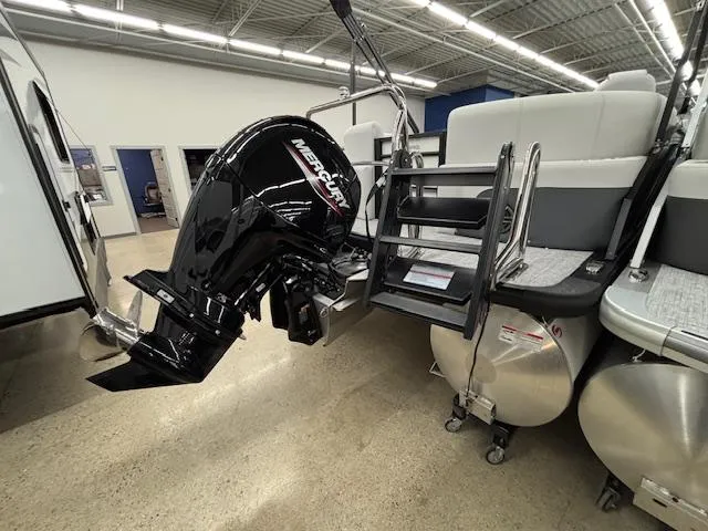 Slide: The Image of 2025 Harris Sunliner 230 pontoon boat with Mercury outboard motor in showroom. - 7
