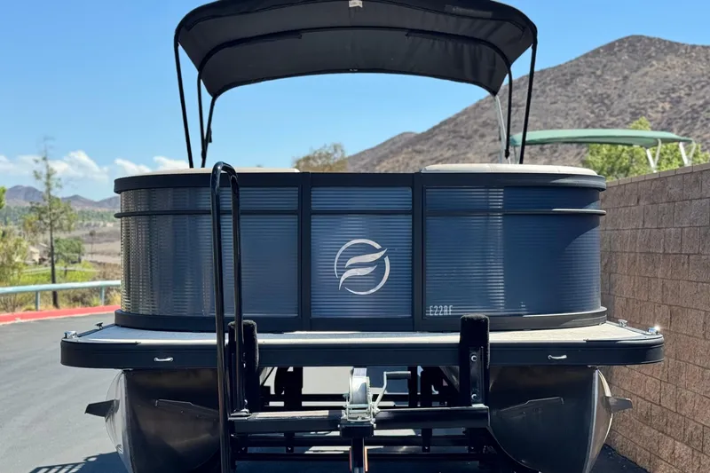 Slide: The Image of 2025 Flagship E22RF pontoon boat parked with scenic mountain backdrop. - 2