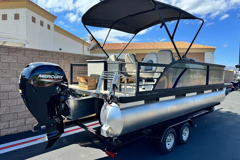 Slide: The Image of 2025 Flagship E22RF pontoon boat with Mercury engine, parked outdoors. - 6