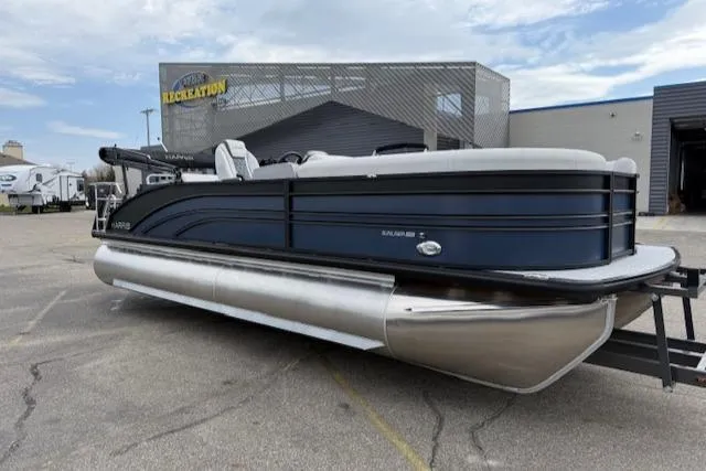 The Image of 2025 Harris Sunliner 230 pontoon boat parked outside a recreational facility. - 1