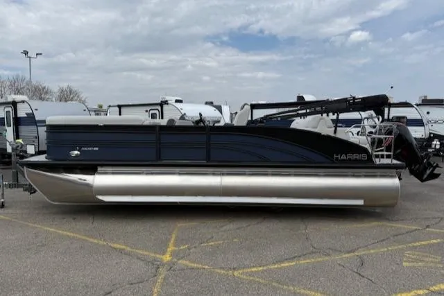 Slide: The Image of 2025 Harris Sunliner 230 pontoon boat parked in a lot, showcasing sleek design and modern features. - 17