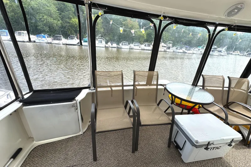 Slide: The Image of 1997 Sea Ray 370 Aft Cabin interior with chairs, table, and river view. - 10