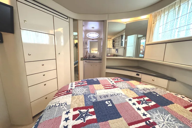 Slide: The Image of 1997 Sea Ray 370 Aft Cabin interior with nautical-themed bedding and elegant cabinetry. - 23