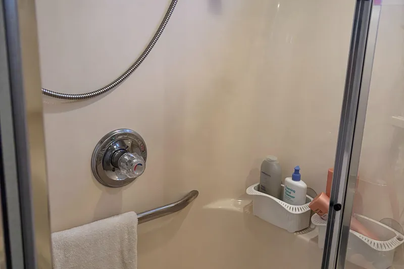 Slide: The Image of Shower area in 1997 Sea Ray 370 Aft Cabin with toiletries and towel. - 29