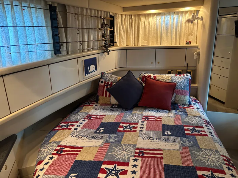 Slide: The Image of Cozy bedroom in 1997 Sea Ray 370 Aft Cabin with nautical-themed bedding and fishing rods. - 31