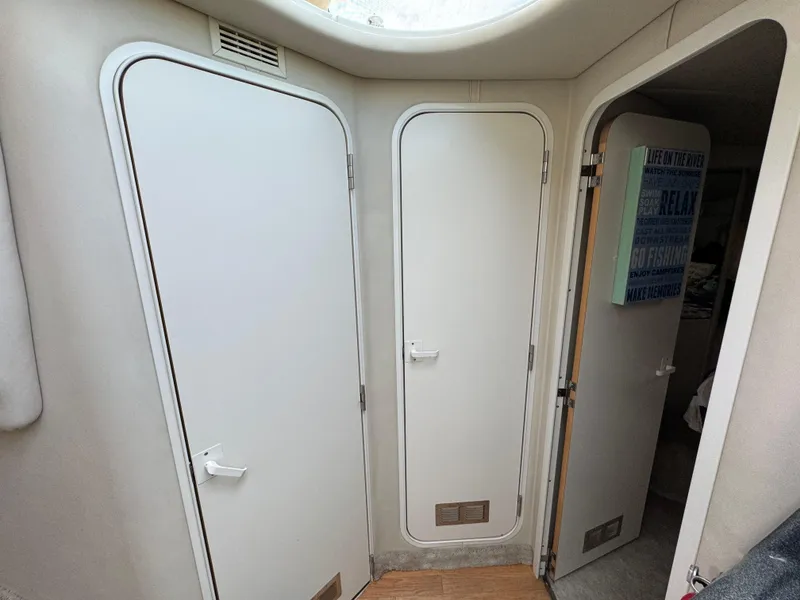 Slide: The Image of Interior view of 1997 Sea Ray 370 Aft Cabin with white doors and wood flooring. - 36