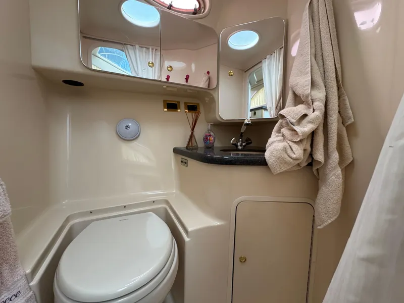Slide: The Image of 1997 Sea Ray 370 Aft Cabin bathroom with toilet, sink, and mirror. - 39