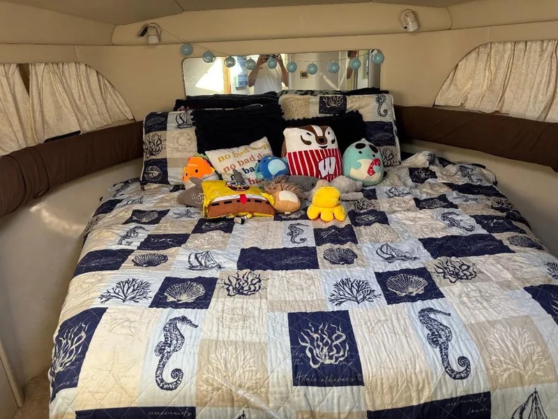 Slide: The Image of Cozy cabin bedroom in 1997 Sea Ray 370 Aft Cabin with nautical-themed bedding and plush toys. - 43
