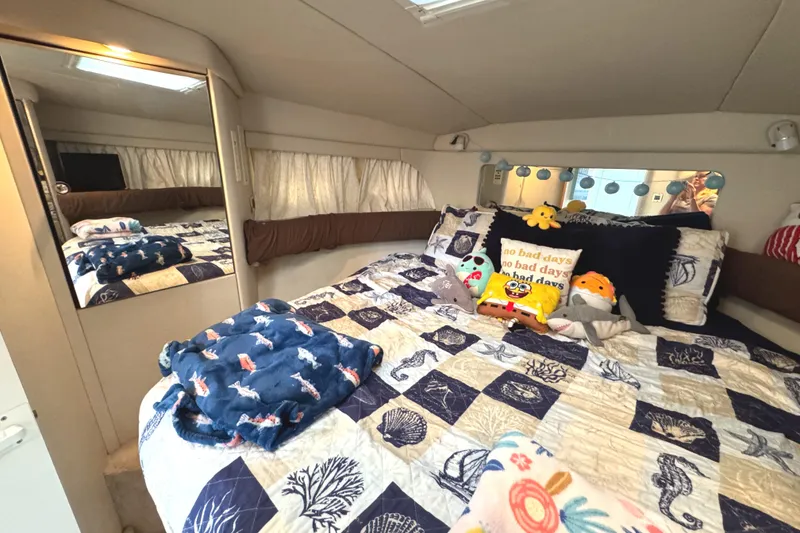 Slide: The Image of Cozy bedroom in 1997 Sea Ray 370 Aft Cabin with nautical-themed bedding and plush toys. - 45