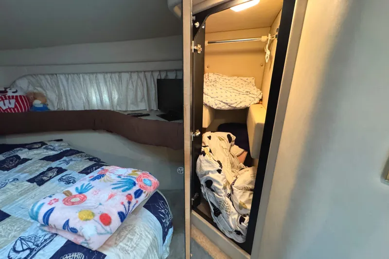 Slide: The Image of Interior of 1997 Sea Ray 370 Aft Cabin with cozy bedding and storage. - 47